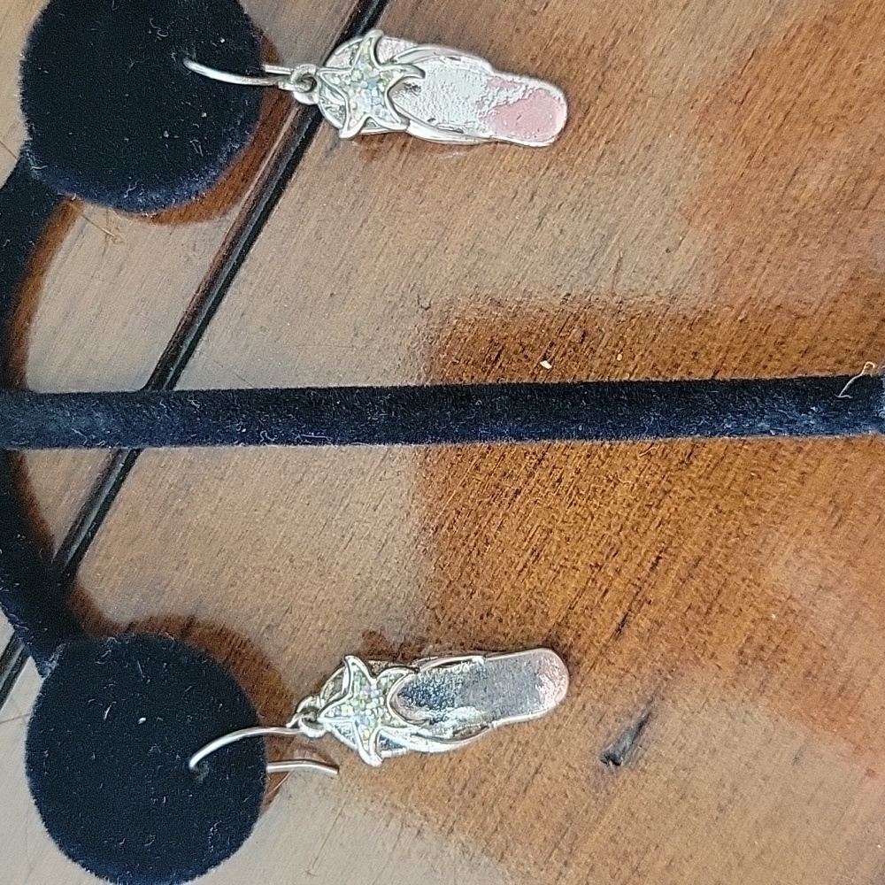 Pair of silver flip flop pierced earrings embellished with rhinestone starfish.